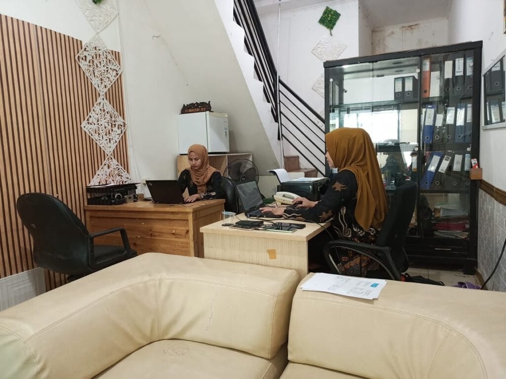 Dua karyawan PT Solusi Mandiri Rekananda, perusahaan jasa konsultan pajak di Bekasi, sedang bekerja di kantor dengan suasana profesional.