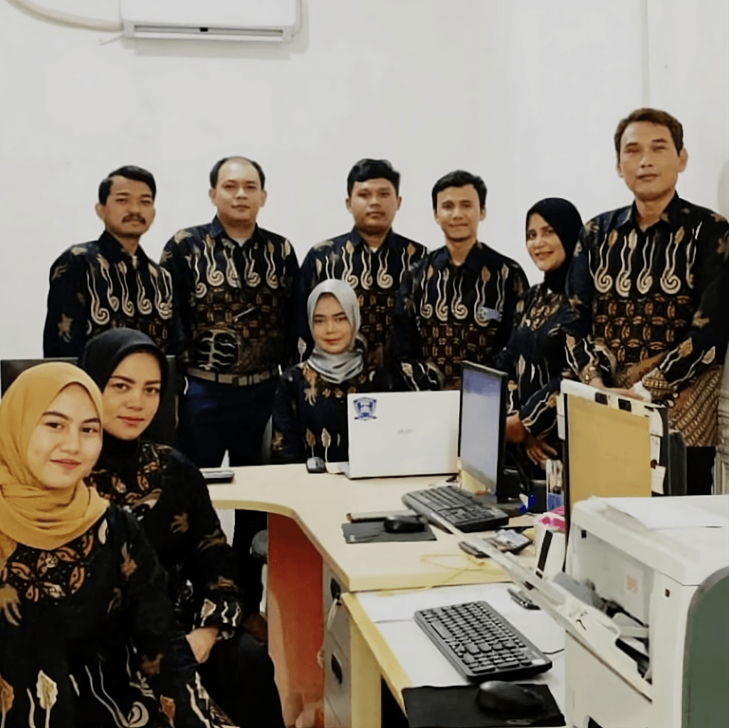 Foto tim profesional PT Solusi Mandiri Rekananda, perusahaan jasa konsultan pajak terpercaya di Bekasi, mengenakan seragam batik, berdiri bersama di kantor mereka.