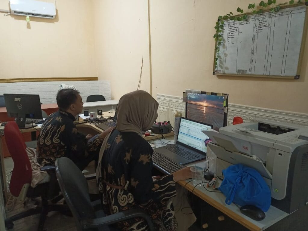 Dua karyawan PT Solusi Mandiri Rekananda, perusahaan jasa konsultan pajak di Bekasi, sedang bekerja di kantor dengan fokus pada tugas-tugas perpajakan.